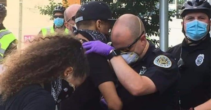 Полицейский штата Теннесси молится с протестующим во время митинга.